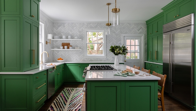 Custom green kitchen with brass hardware and herringbone tile backsplash in a Dilworth remodel by Hopedale Builders