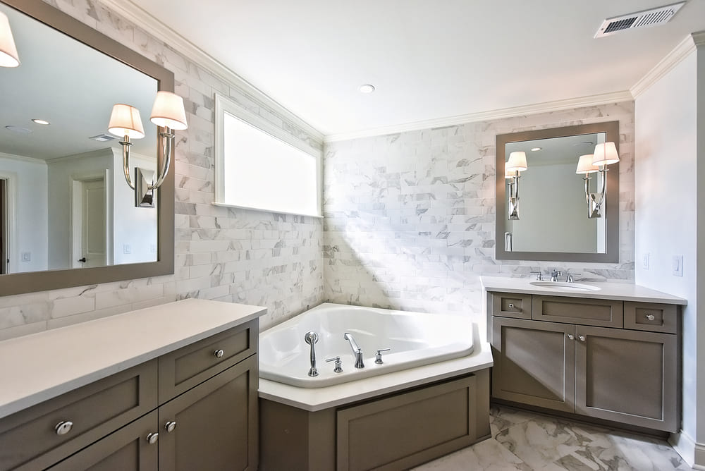 beige tiled master bathroom with large corner tub by hopedale builders in charlotte nc