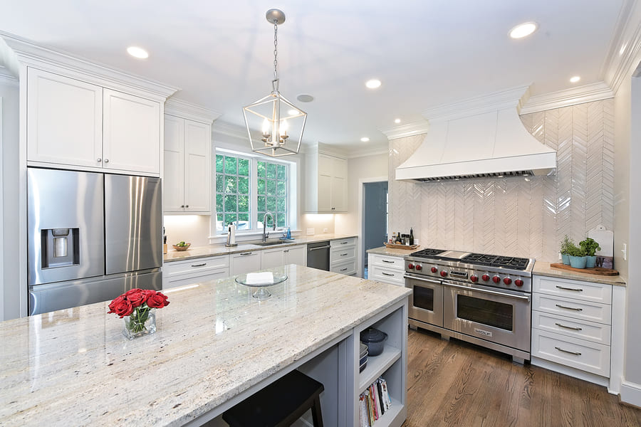 Kitchen with white countertops on island and brown floors by Hopedale Builders in charlotte nc