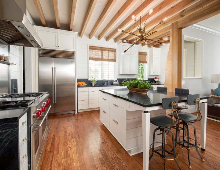 Remodeled kitchen with hardwood floors and black chairs by Hopedale Builders in Charlotte, NC