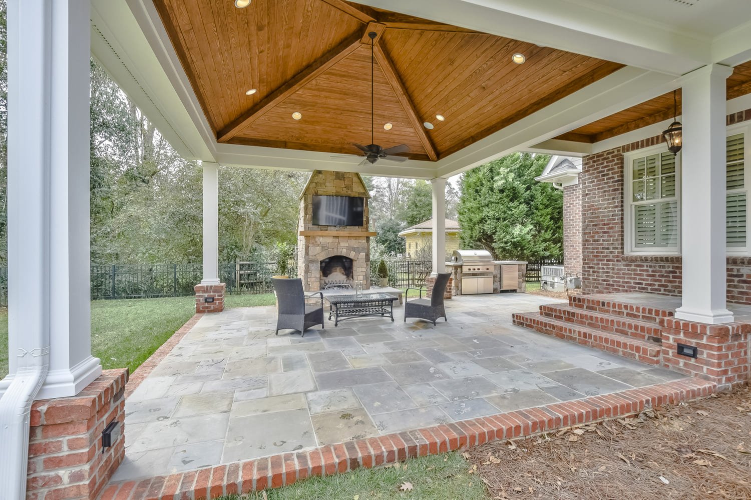 grey brick covered patio with outdoor fireplace by hopedale builders in charlotte nc