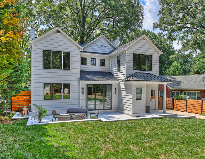 Exterior of remodeled home with chairs and couch in the backyard by Hopedale Builders in Charlotte, NC