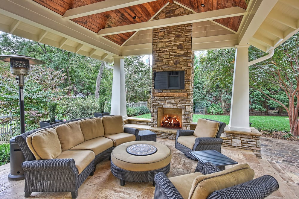 Malloy outdoor living space covered porch with stone fireplace and brown furniture in Charlotte, NC by Hopedale Builders Malloy outdoor living space covered porch with stone fireplace and brown furniture in Charlotte, NC by Hopedale Builders